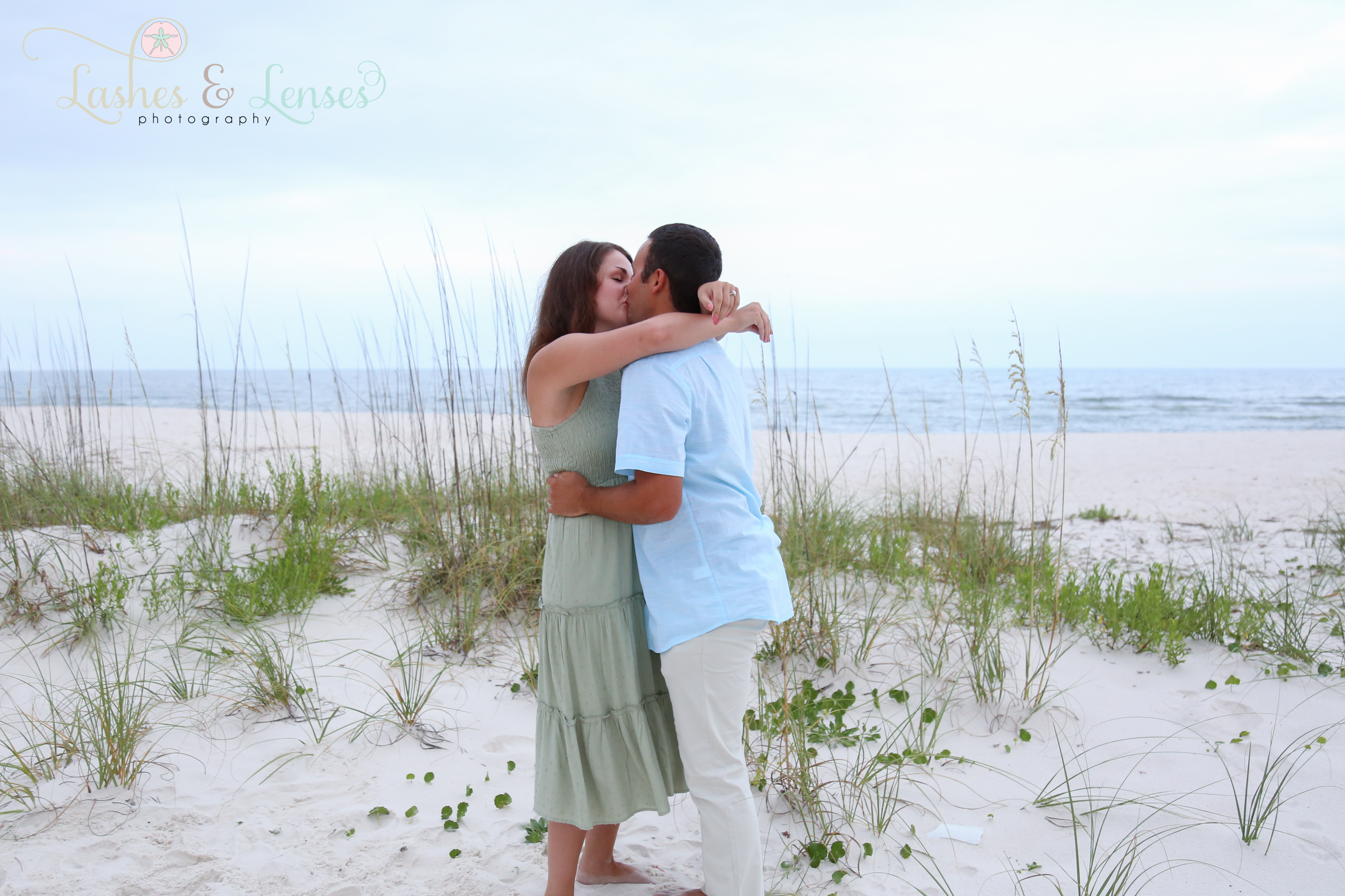 Engaged couple kissing in the sand at Johnsons Beach Perdido Key