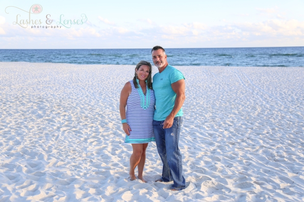 Couple with the gulf behind them looking at the camera at Johnsons Beach in Perdido Key