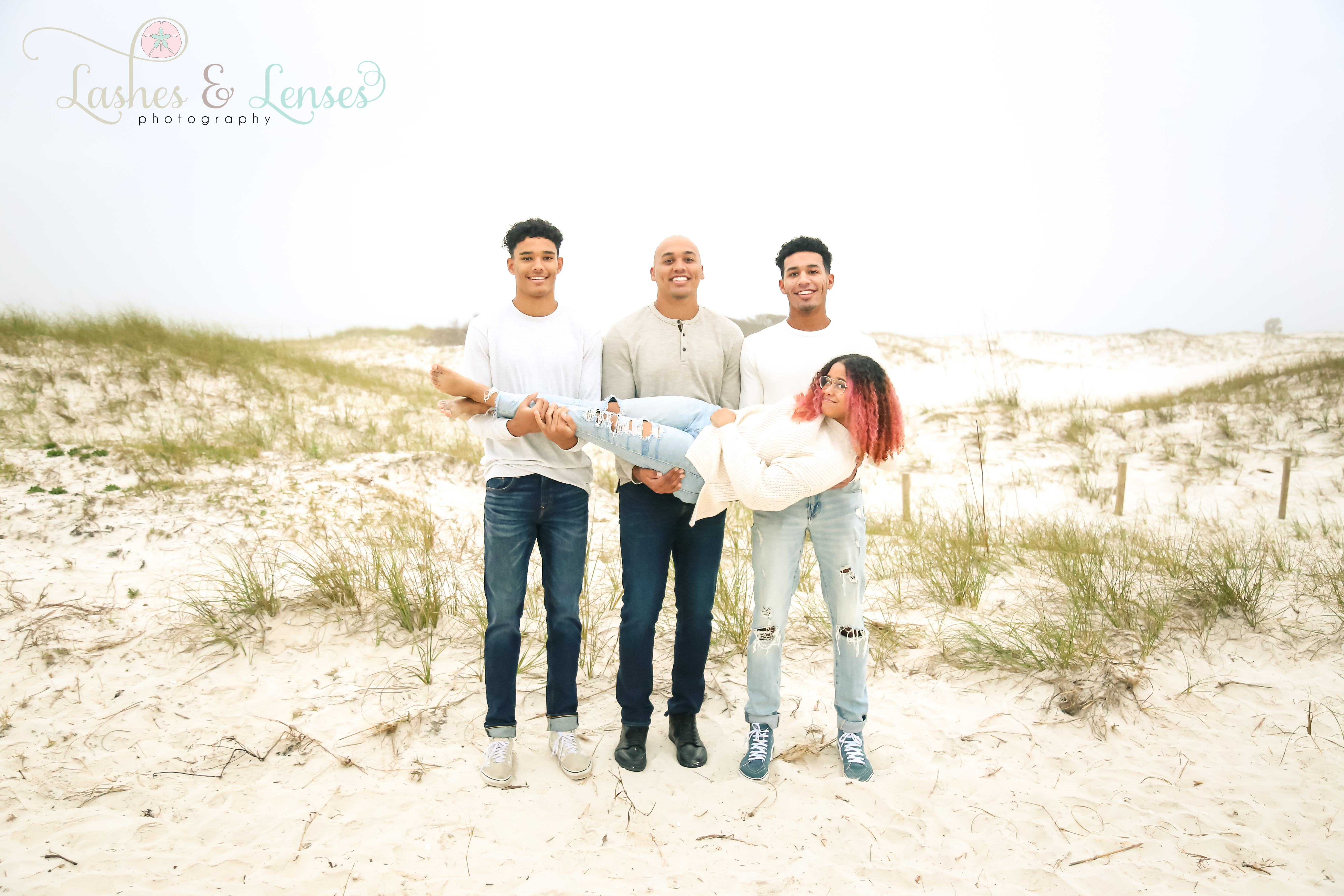 Brothers holding sister in the sand dunes at Johnsons Beach in Perdido Key