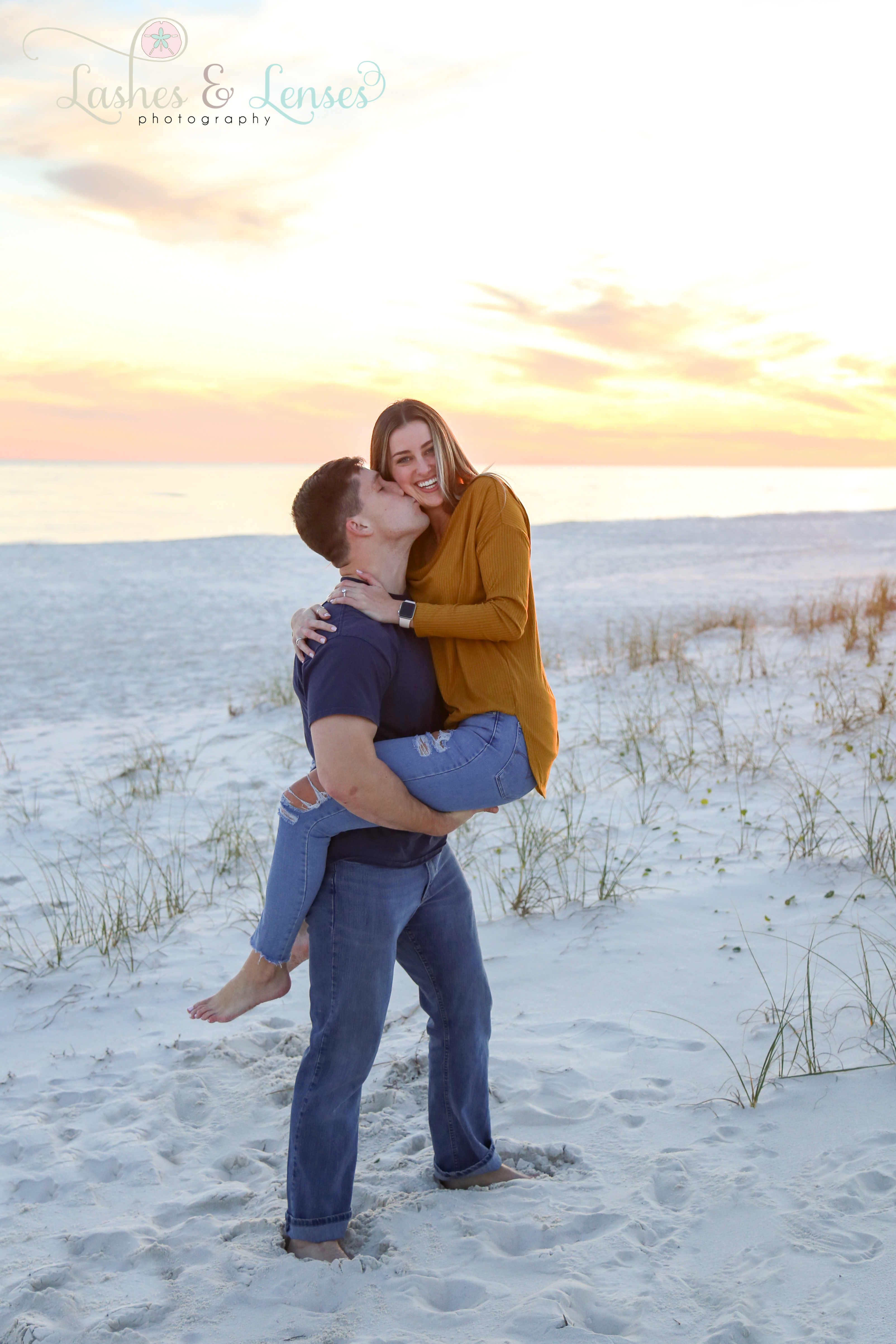 Young man holding his new fiancé at Johnsons Beach in Perdido Key