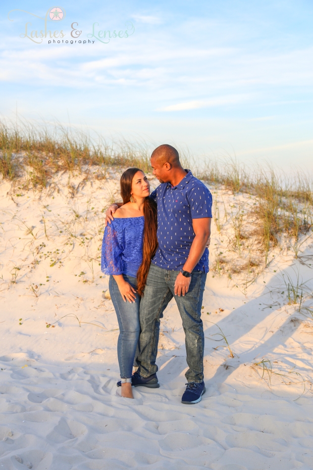 Couple in blue shirts and blue jeans looking at each other on the boardwalk at Johnsons Beach in Perdido Key