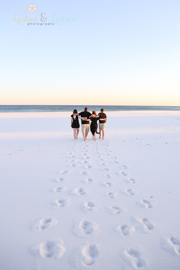 Family walking hand in hand towards the water at Johnsons Beach in Perdido Key