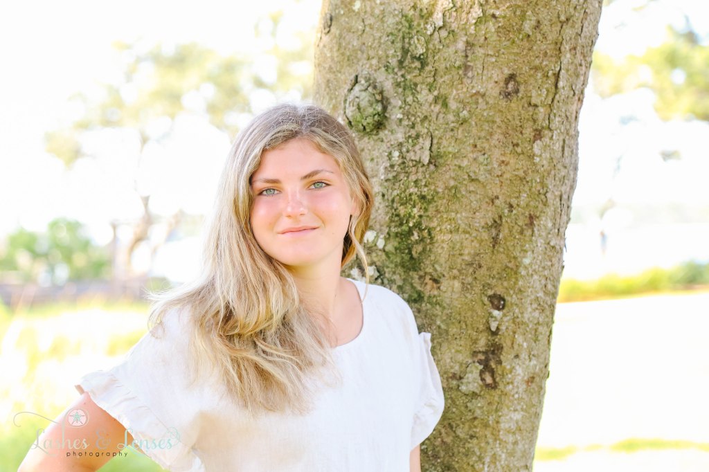 Close up photo of teen girl leaning against large tree at Innerarity Point Park in Pensacola, Florida
