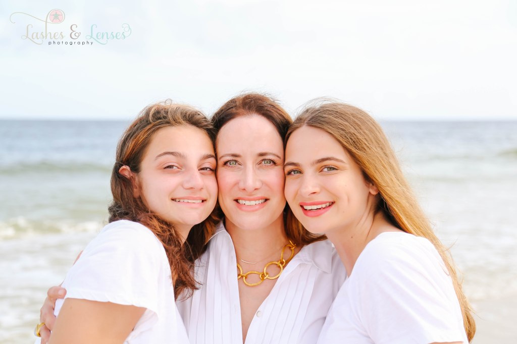 Close up of Mom and her two teen daughters standing with the water h=behind them at Johnsons Beach in Perdido Key Florida