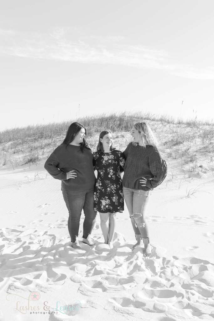 Teen girl cousins all looking at each other and laughing at Johnsons Beach in Perdido Key, Fl