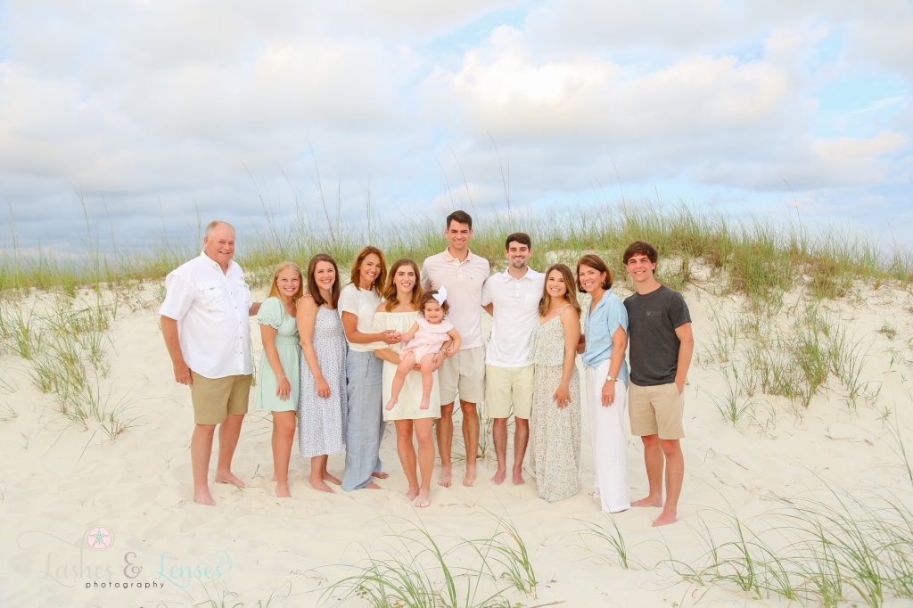 Extended family standing in front of a large sand dune at Johnsons Beach in Perdido Key, Florida