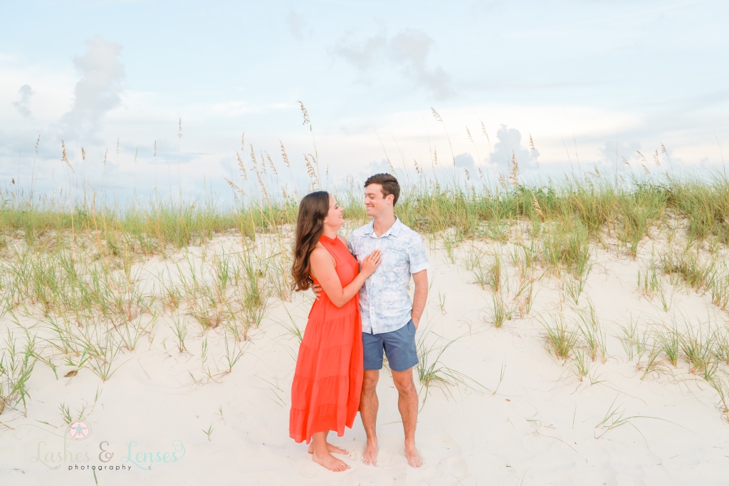 Young couple standing on the beach looking into each others eyes at Johnsons Beach in Perdido Key, Florida