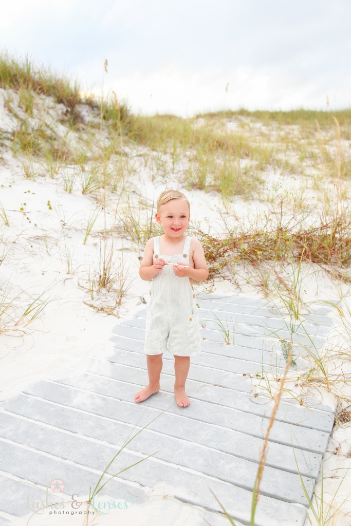 Toddler boy holding a starfish at Johnsons Beach in Perdido Key, Florida